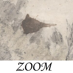 May include: A close-up of a textured, light gray background with a brown splatter of paint. The splatter is shaped like a teardrop and is slightly blurred. There are also some faint gray lines and shapes in the background.