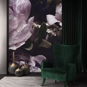 Puede incluir: Un sill&oacute;n de terciopelo verde con respaldo alto y brazos de ala se encuentra frente a una pared con papel tapiz floral. Tres jarrones decorativos est&aacute;n en el suelo frente al sill&oacute;n.