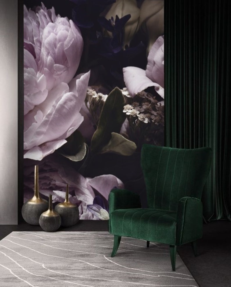 Puede incluir: Un sill&oacute;n de terciopelo verde con respaldo alto y brazos de ala se encuentra frente a una pared con papel tapiz floral. Tres jarrones decorativos est&aacute;n en el suelo frente al sill&oacute;n.