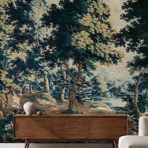 European antique tapestry wallpaper in rich deep blue, green, and warm earthy tones, featuring mature trees, lush woodland foliage and a tranquil pond, styled with a mid-century wooden sideboard, sculptural ceramics, and soft neutral seating. The exquisite, timeless elegance of 17th-century Verdure style blends classical artistry with handcrafted warmth to bring historical beauty and natural poetry into your home, for those who want to elevate their interiors with refined heritage character.