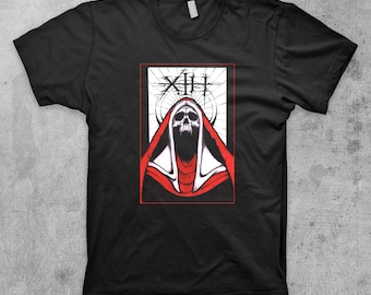 May include: Black t-shirt with a graphic of a skull wearing a red hooded robe. The graphic is in a white rectangle with the text "XIII" at the top.