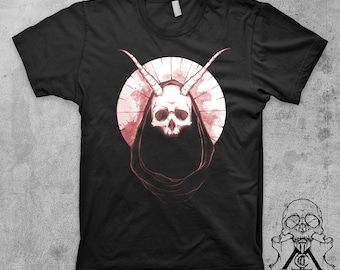 May include: Black t-shirt with a graphic of a skull with horns wearing a hooded robe. The skull and robe are in shades of pink.