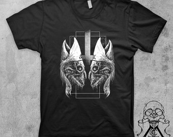 May include: Black t-shirt with a white graphic of two stylized heads wearing pointed hats, facing each other, with a cross in between them.