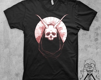 May include: Black t-shirt with a graphic of a skull with horns wearing a hooded robe. The skull and robe are in shades of pink against a white circle.