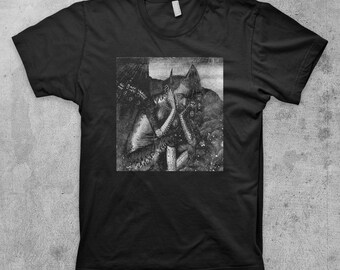 May include: Black t-shirt with a graphic print of a black and white illustration of a creature with a horned head and a human-like body.