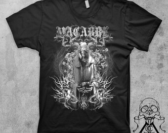 May include: Black t-shirt with a white graphic print of a hooded figure with horns and a skull face. The graphic is surrounded by branches and vines. The text "MACABRE" is printed above the figure.