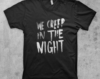 May include: Black t-shirt with white text that reads "We Creep in the Night".