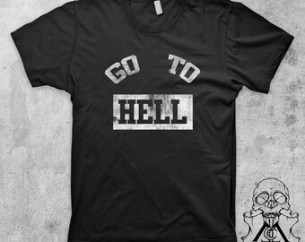 May include: Black t-shirt with the words "GO TO HELL" in distressed white lettering. The shirt has a crew neck and short sleeves. A skull graphic is visible in the lower right corner.