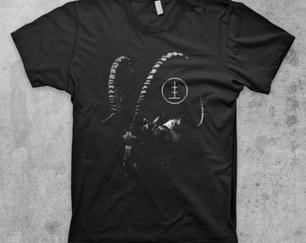 May include: Black t-shirt with a white graphic of a goat's head with horns and a circle with a symbol inside.