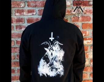 May include: Black hooded sweatshirt with a white graphic print of a goat's head with horns and an inverted cross.