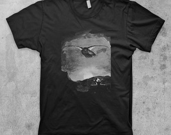 May include: Black t-shirt with a graphic print of a bat flying in a cloudy sky.