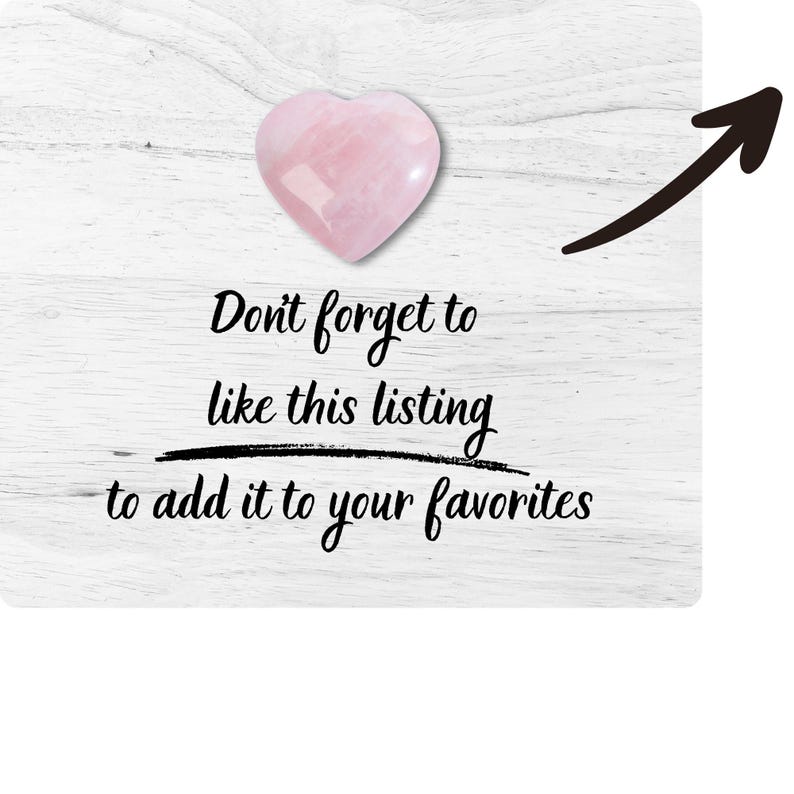 May include: A pink heart-shaped crystal with the text "Don't forget to like this listing to add it to your favourites" on a white wooden background.