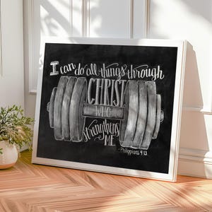 May include: A framed chalkboard art print with a white border. The black chalkboard features a barbell illustration and the text "I can do all things through Christ who strengthens me - Philippians 4:13" in white.