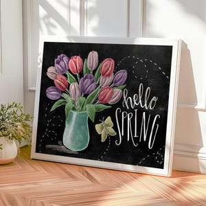 Puede incluir: Impresi&oacute;n art&iacute;stica enmarcada con fondo negro, que muestra un jarr&oacute;n turquesa lleno de tulipanes en tonos rosa, morado y rojo. Las palabras "hello SPRING" est&aacute;n escritas en blanco, acompa&ntilde;adas de una ilustraci&oacute;n de mariposa.