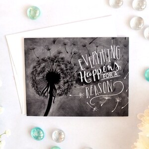 May include: A black and white illustration of a dandelion with the text "Everything Happens for a Reason" written in white on a gray background.