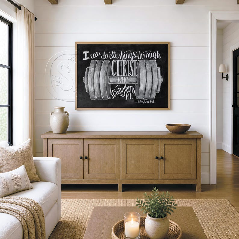 May include: A rectangular wall art piece featuring a black chalkboard background with a white illustration of a dumbbell and the text I can do all things through CHRIST WHO strengthens ME - Philippians 4:13, framed in a light wood border.