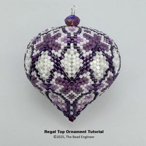 Puede incluir: Adorno de cuentas en forma de lágrima, con un patrón geométrico en tonos morados y blancos. Tiene un lazo plateado y una pequeña cuenta iridiscente. El texto en la imagen dice "Regal Top Ornament Tutorial" y "©2025, The Bead Engineer."