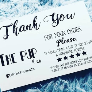 Puede incluir: Una tarjeta de agradecimiento blanca con texto negro que dice "Gracias" y "The Pup & Co." con un identificador de redes sociales para la empresa. La tarjeta también incluye un sistema de calificación de cinco estrellas y un mensaje pidiendo a los clientes que dejen una reseña.