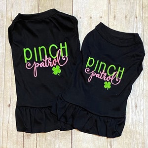 May include: Two black dog shirts with a green and pink embroidered design that says "Pinch Patrol" with a shamrock.