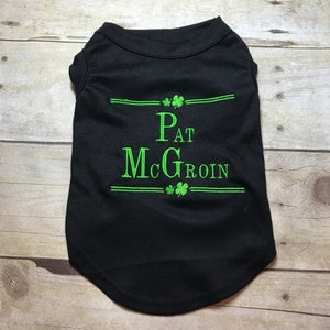 May include: Black dog shirt with green shamrock embroidery and the text "Pat McGroin".