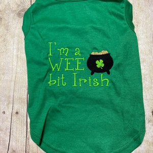 May include: Green dog shirt with the text "I'm a wee bit Irish" and a black pot of gold with a shamrock.