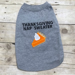 May include: Gray dog shirt with the text "Thanksgiving Nap Sweater" and an embroidered pumpkin pie slice.