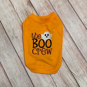 May include: A yellow dog shirt with the text "the BOO crew" and a white ghost graphic.