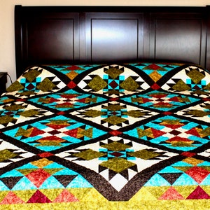 Può includere: Un letto con una testiera marrone e un piumone con un motivo geometrico colorato. Il piumone presenta sfumature di verde, marrone, bianco, rosso e blu.