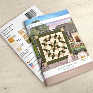 May include: A quilt pattern booklet for a Log Cabin Carpenters' Star quilt. The quilt is king size, measuring 105 inches by 105 inches. The quilt pattern is by Judit Hajdu and features a green, beige, and yellow color scheme.