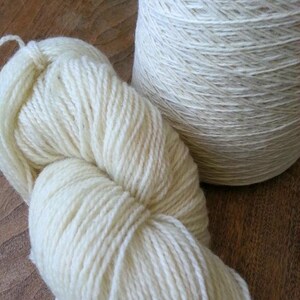 May include: Two skeins of white yarn, one wound into a ball and the other in a skein.
