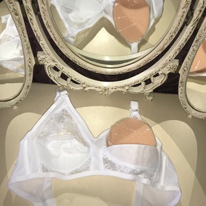 Può includere: Reggiseno in pizzo bianco con imbottitura rimovibile. Il reggiseno ha spalline regolabili e chiusura a gancio e occhiello sul retro.