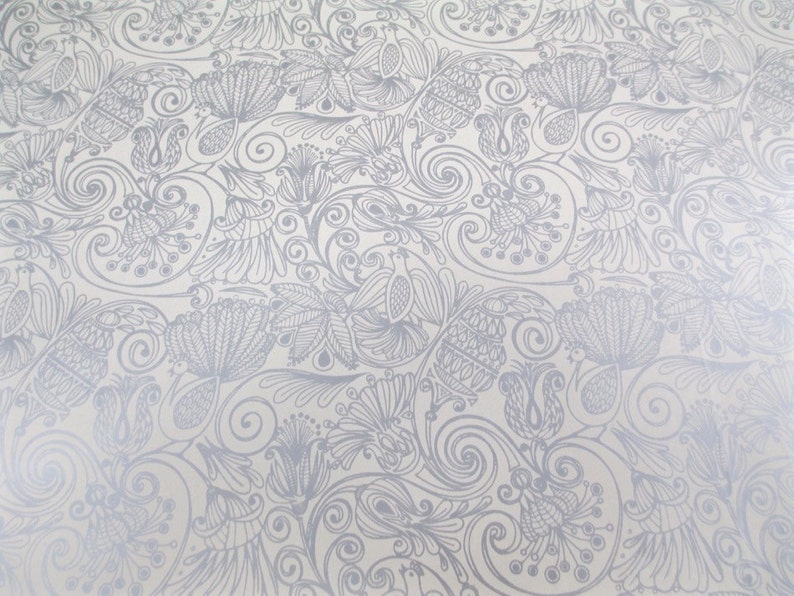 May include: A white background with a silver floral pattern. The pattern is made up of swirls, leaves, and flowers.