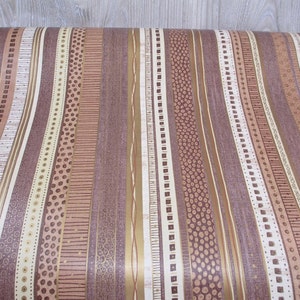 May include: A roll of brown and beige striped wallpaper with a variety of patterns, including dots, lines, and squares.