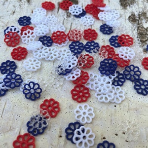 May include: Assortment of red, white, and blue decorative paper flowers. The flowers are made of a delicate, lacy material and are perfect for adding a touch of elegance to any craft project.