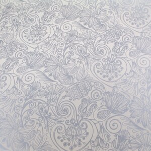 May include: A white background with a silver metallic pattern of swirling vines and flowers.