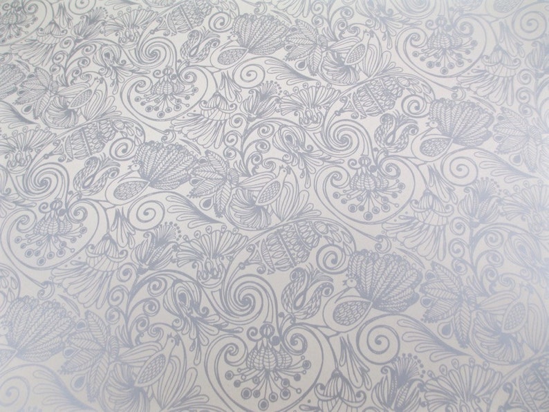 May include: A white background with a silver metallic pattern of swirling vines and flowers.