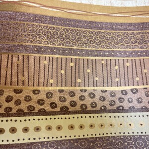 May include: A brown and gold patterned wallpaper with a repeating design of circles, dots, and lines.
