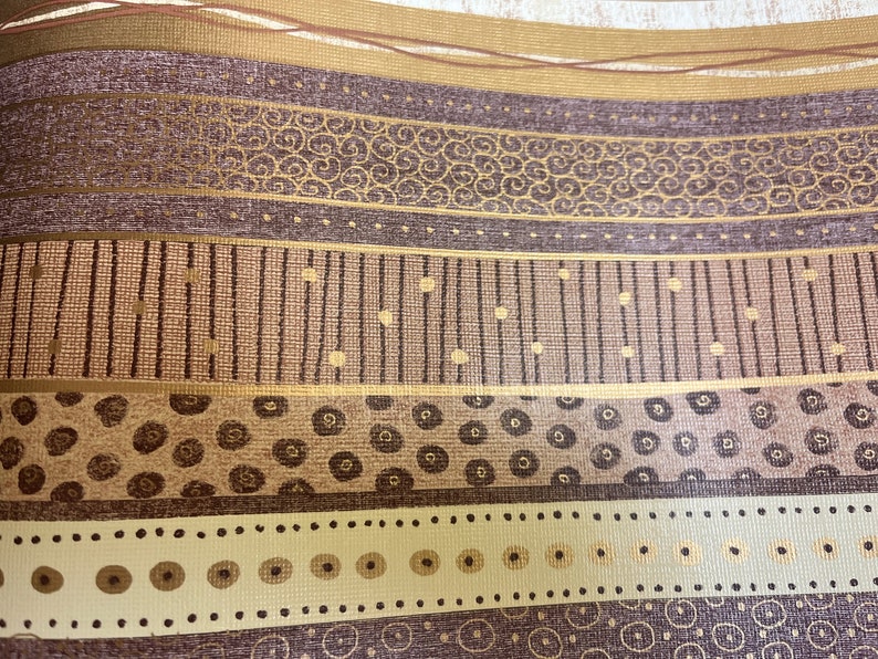 May include: A brown and gold patterned wallpaper with a repeating design of circles, dots, and lines.