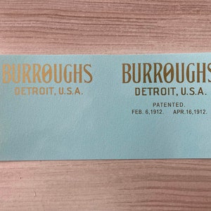 May include: A light blue label with gold lettering that reads "BURROUGHS DETROIT, U.S.A. PATENTED. FEB. 6, 1912. APR. 16, 1912."