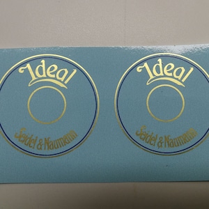 May include: Two blue and gold round stickers with the text "Ideal Seidel & Naumann" in gold lettering.