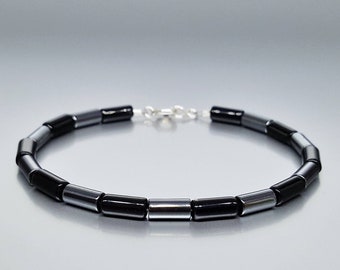 May include: A black and silver beaded bracelet with a silver clasp.