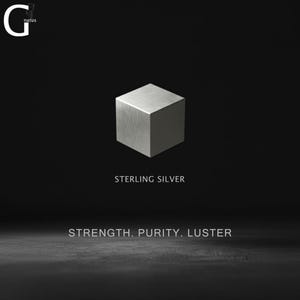 May include: A metallic silver cube centered against a black background. The text G natus appears in the top left corner. Below the cube, the text reads STERLING SILVER, followed by the words STRENGTH. PURITY. LUSTER in a clean, sans-serif font.