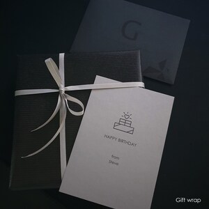 May include: A black gift box with a white ribbon and a white card that says "Happy Birthday from Steve" with a small cake icon.