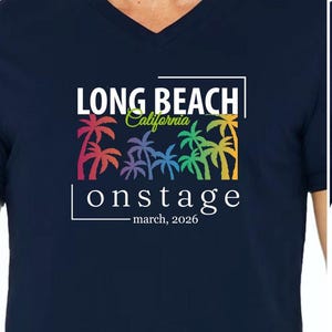 May include: Two navy blue t-shirts, one with a V-neck and the other with a crew neck, featuring a colorful palm tree design. The shirts display the text "LONG BEACH California onstage march, 2026" in white.