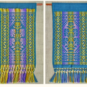 Op de afbeelding: Twee tealblauwe wandkleden met kleurrijke geometrische patronen en franjes. De patronen zijn in tinten geel, paars en roze.