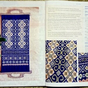 May include: A page from a book showing a blue and white embroidered design with the text "Peace to Your Home!" and "A Symbolic Embroidery Design." The design is a long, rectangular shape with intricate patterns.