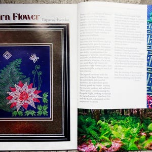 May include: A magazine page with the title "The Fern Flower" and a close-up image of a fern flower embroidery design. The embroidery is done in shades of green, pink, and white on a dark blue background. The text "Paparac-kvetka" is also visible on the page.