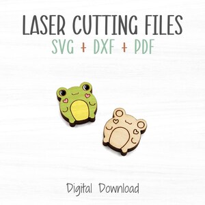 May include: Two laser cut wooden frog shapes, one green and one natural wood colour. Both frogs have small hearts on their cheeks. The text "LASER CUTTING FILES SVG + DXF + PDF" is above the frogs. The text "Digital Download" is below the frogs.