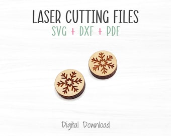May include: Two laser cut wooden snowflake ornaments. The snowflakes are cut out of a round piece of wood and have a brown color. The text "LASER CUTTING FILES" and "SVG + DXF + PDF" is above the ornaments. The text "Digital Download" is below the ornaments.