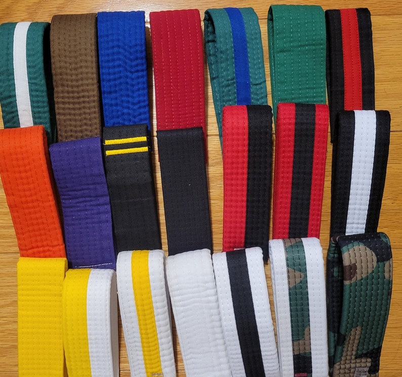 May include: A collection of 15 different colored belts with various patterns and designs. The belts are made of a woven fabric and have a variety of colors, including black, white, red, blue, green, and brown.